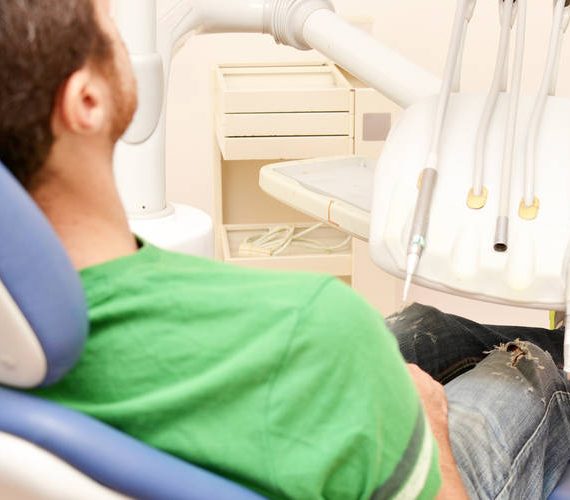 Ασθενής κάθεται στην οδοντιατρική καρέκλα